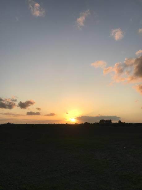 istock Sunset over land with clouds and blue sky 1175063581