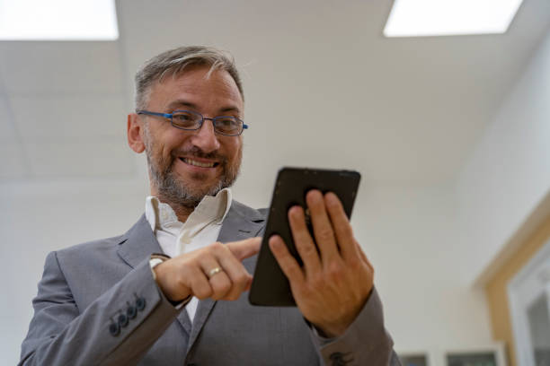 istock Smiling Middle Aged Businessman With Tablet Computer 1175063604