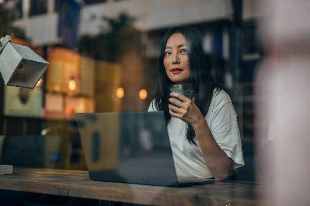istock Pretty woman drinking coffee and using laptop 1175064354