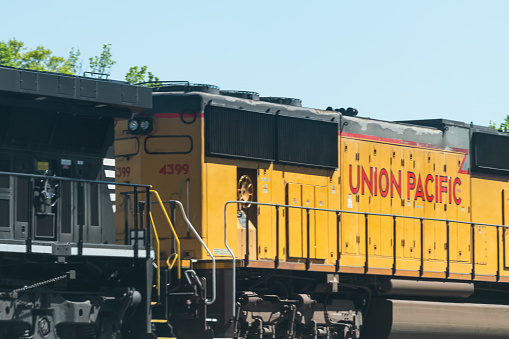 Atlanta, USA - April 20, 2018: Union Pacific locomotive cargo freight train with cars passing on railroad tracks in Georgia downtown midtown city in summer