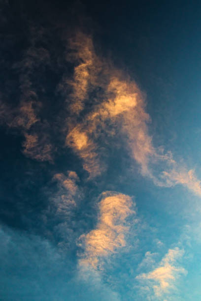 thin clouds lit by the evening sun. - vertical bright brightly lit vibrant color imagens e fotografias de stock