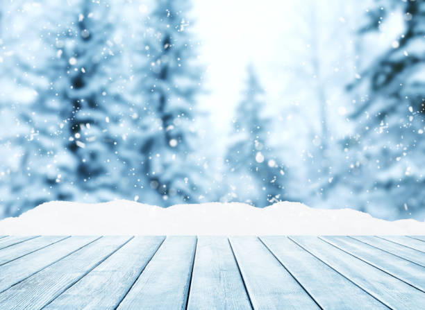 istock Wooden table top on winter sunny landscape with fir trees. 1175075475