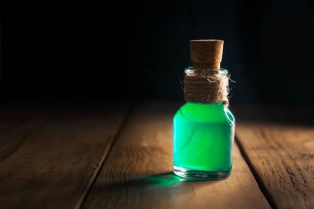 istock Green poison magic bottle on black and wooden background. Copy space. Selective focus 1175075603