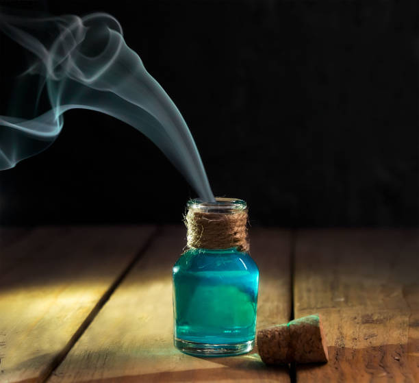 Poison with smoke in magic bottle on black and wooden background. Selective focus Poison with smoke in magic bottle on black and wooden background. Selective focus. potion bottle retro revival old fashioned stock pictures, royalty-free photos & images