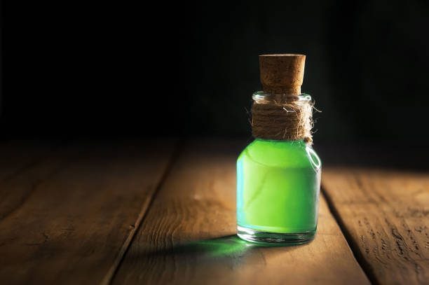 istock Potion in magic bottle on black and wooden background. Copy space. Selective focus 1175075675