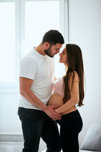 istock Husband hugging and touching his pregnant wife's belly. 1175080077