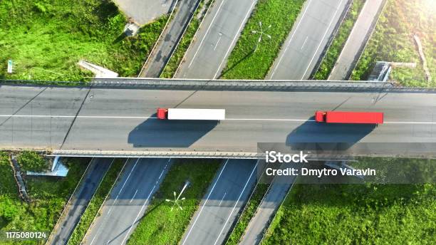 Truck Logistics Aerial Two Trucks Motion By The Highway Intersection Road Between Fields View From Drone Stock Photo - Download Image Now
