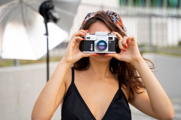 istock Female with analog photo camera over her face 1175081208