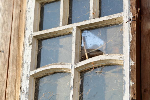 istock Old window with a wooden frame. Frame with peeling paint. Covered with dust and cobwebs. Dirty glass. 1175084274