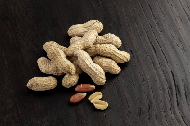 istock a group of shelled peanuts on wood background 1175084836