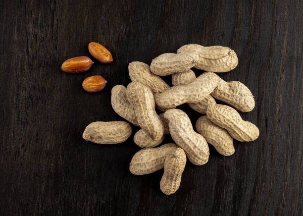 istock a group of shelled peanuts on wood background 1175084851