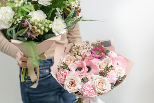 Beautiful bouquet of mixed flowers in woman hand. the work of the florist at a flower shop. Delicate Pastel color. Fresh cut flower.