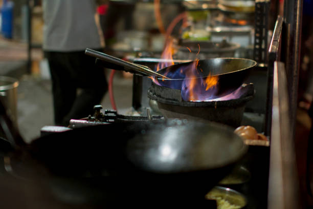 The chef heats up the oil in the wok ready for cooking stock photo