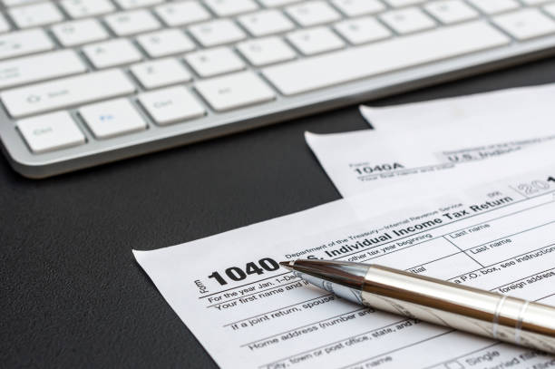 istock Tax form with computer keyboard and pen at workplace. 1175088584