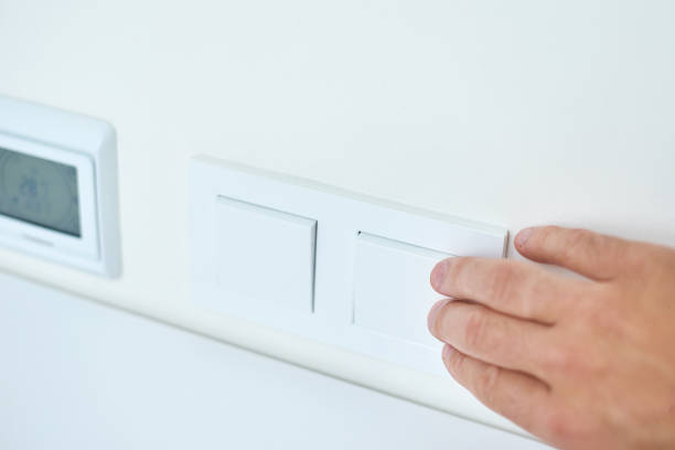 istock Hand is turning on or off on light switch, closeup 1175090494