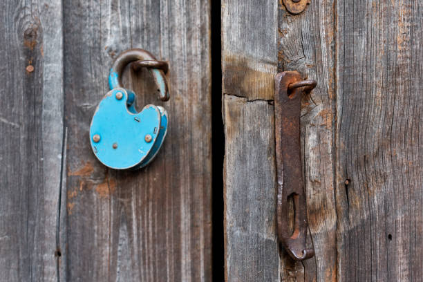 istock Blue old rusty unlocked padlock on wooden door 1175090517