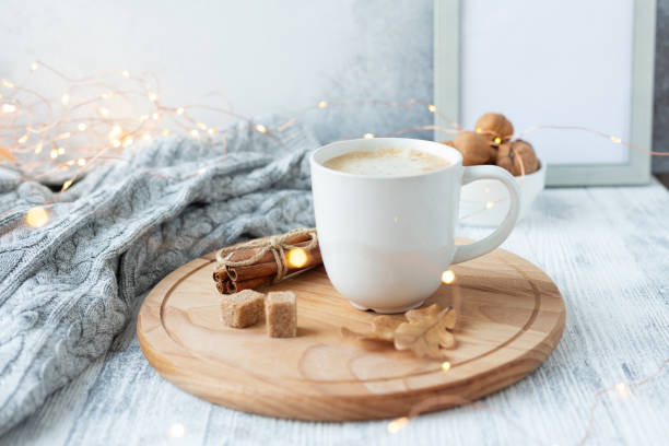 Coffee mug, sweater, cinnamon, decorated with led lights. Autumn mood. Cozy autumn composition. Hygge concept Soft focus stock photo