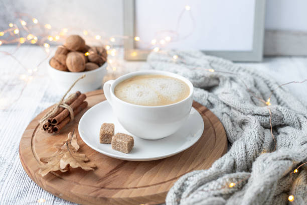 Cup of coffee, brown sugar, knitted scarf, garland. Autumn mood. Cozy autumn composition. Hygge concept stock photo