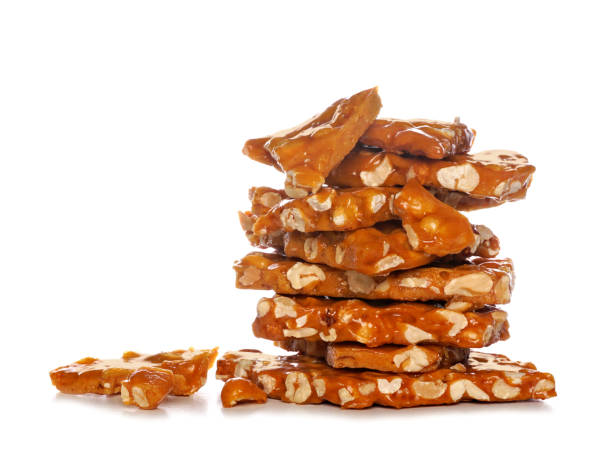 Stack of traditional peanut brittle candy pieces, isolated on white