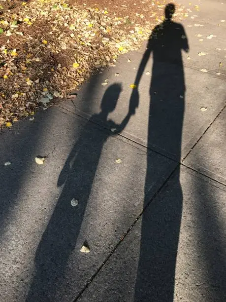 Shadow of a father and child holding hands