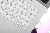 White Apple Macbook laptop with dvd disk in slot. Isolated.