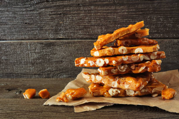istock Stack of traditional peanut brittle candy pieces against rustic wood 1175099630