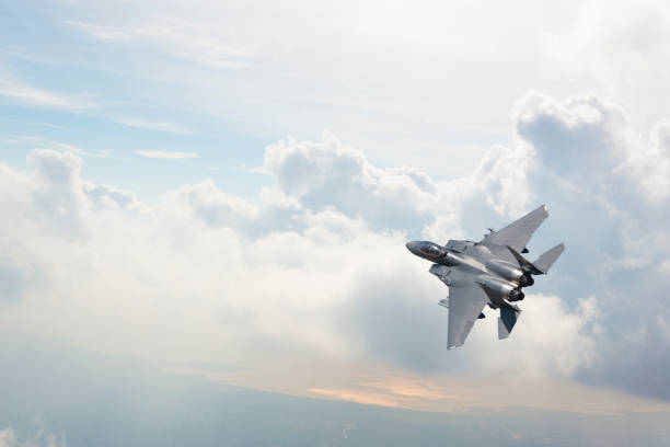 f-15 kampfjet fliegt über wolken - verteidigen stock-fotos und bilder