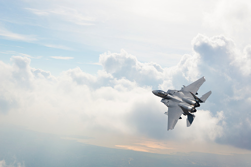 F-15 Fighter Jet flying over clouds