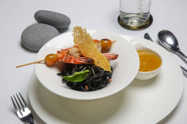 istock Black ink linguini pasta with roasted prawn skewer. Exquisite dish. Creative restaurant meal concept. 1175104513
