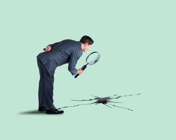 istock Businessman Inspecting Hole And Cracks With Magnifying Glass 1175106061