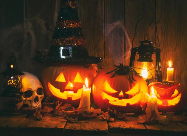 Photo of Halloween Jack-o-Lantern Pumpkins on rustic wooden background