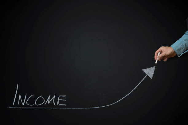 istock Income Text and Arrow on Blackboard with male hand writing with chalk 1175110691