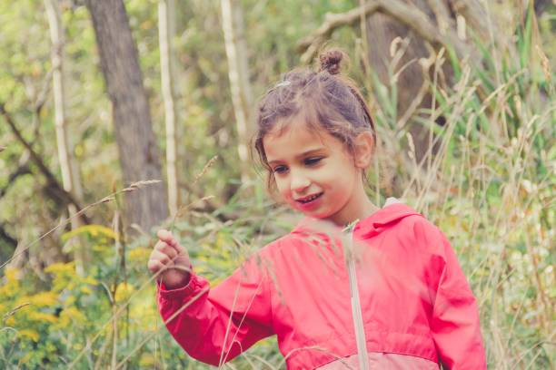 istock Girl explores meadow in her raincoat 1175120069