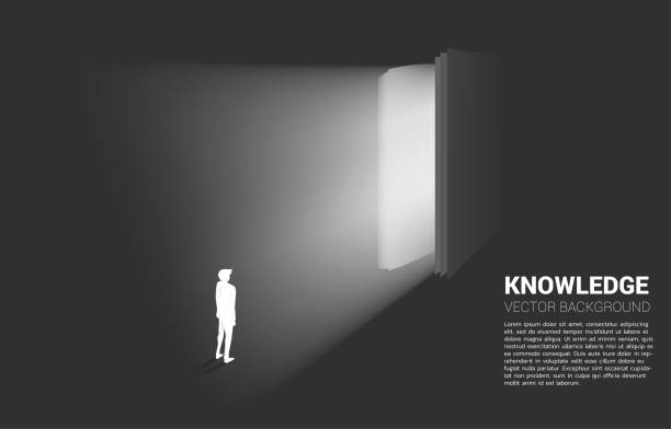 istock Silhouette of businessman standing in light from open book. 1175121990