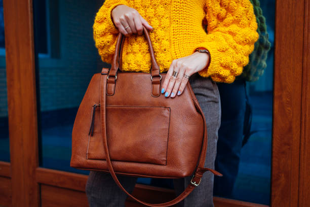 handbag. woman holding stylish bag and wearing yellow sweater. autumn female clothes and accessories. fashion - purse bag glamour personal accessory imagens e fotografias de stock