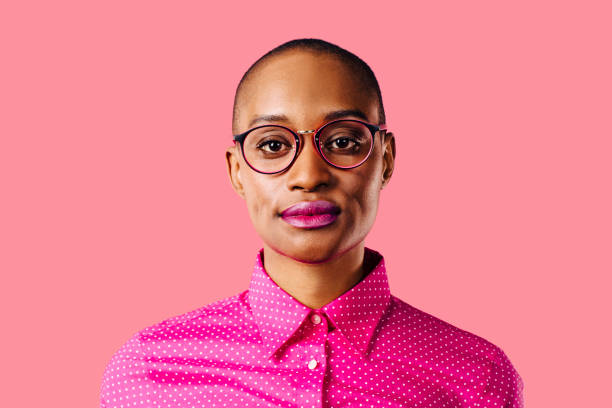 retrato de una joven inteligente con camisa rosa y gafas, aislada en el fondo rosa estudio - decisions teenage girls horizontal studio shot fotografías e imágenes de stock