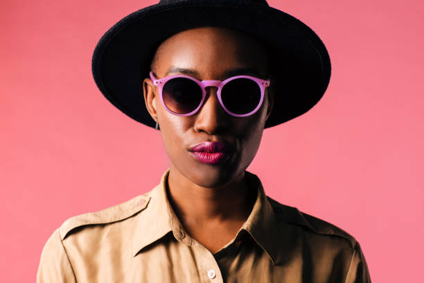 분홍색 스튜디오 배경에 고립 된 보라색 선글라스를 쓴 젊은 여성의 초상화 - sunglasses women studio shot isolated 뉴스 사진 이미지