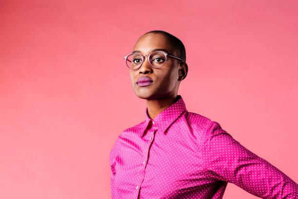 retrato de una joven con gafas y camisa rosa, aislada sobre fondo de estudio rosa - decisions teenage girls horizontal studio shot fotografías e imágenes de stock