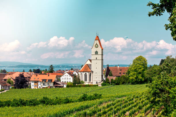 z panoramicznego widoku na jezioro bodeńskie roztacza się panoramiczny widok na jezioro. zeppelin, jabłonie i kościół katolicki święty johann chrzciciel w hagnau na zdjęciu. - hagnau zdjęcia i obrazy z banku zdjęć