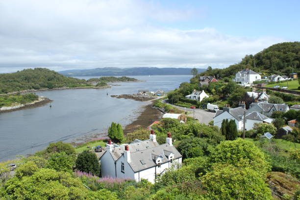 Coastal Houses Houses hugging the coastline at the entrance to Tarbert harbour. loch fyne stock pictures, royalty-free photos & images