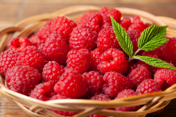 istock Red fresh raspberries on brown rustic wood background 1175128186