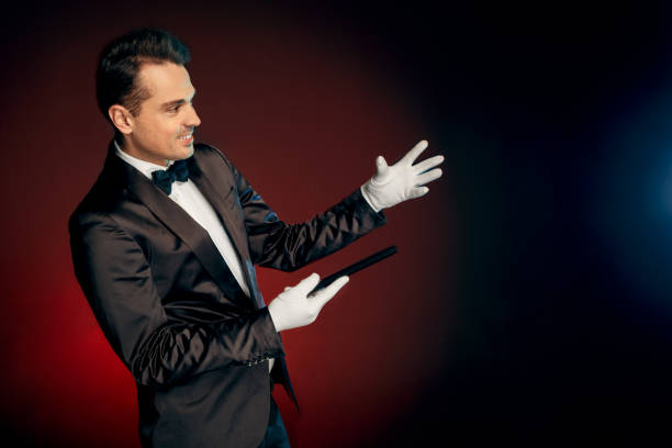 istock Professional Occupation. Showman in suit standing isolated on wall making trick with cane smiling happy 1175130340