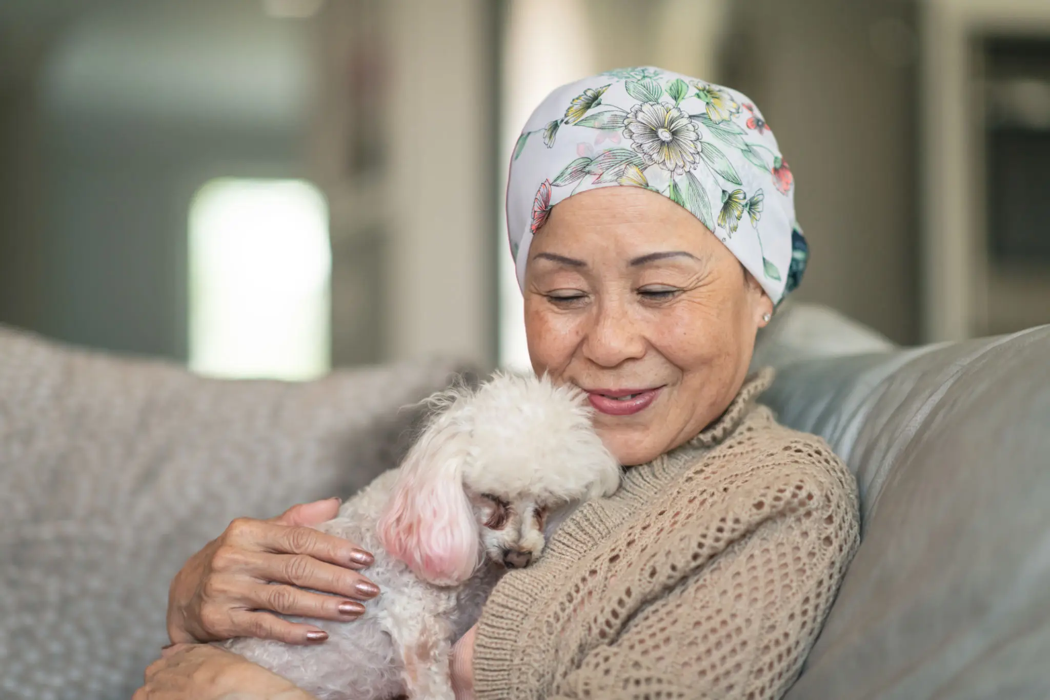 Woman with cancer relaxes at home with her pet dog