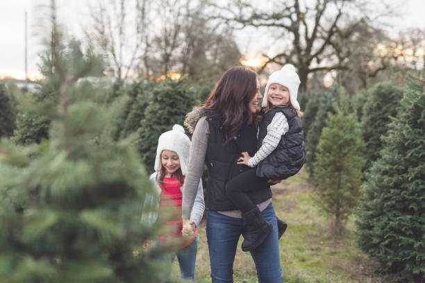 istock Mom walks through a Christmas tree farm with her daughters 1175136274