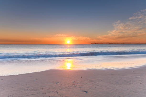 Atlantic ocean sunset with surging waves at Fonte da Telha beach, Costa da Caparica, Portugal