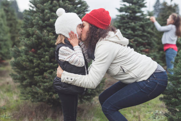 istock Mom adjusts her daughter's hat at a Christmas tree farm 1175136802