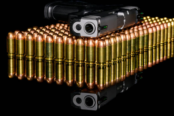 istock Semi-Automatic Handgun on rows of ammo, ammunition with black background and reflection 1175140901