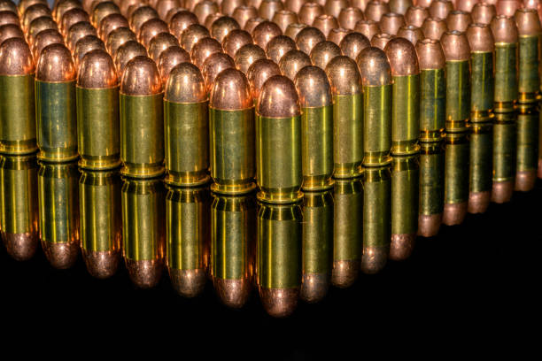 Neat Rows of handgun ammunition on black background with reflection
