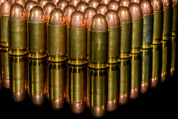 istock Neat Rows of handgun ammunition on black background with reflection 1175140933