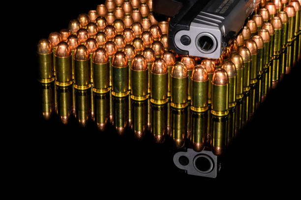 pistola semiautomatica su file di munizioni, munizioni con sfondo nero e riflessione - second amendment foto e immagini stock